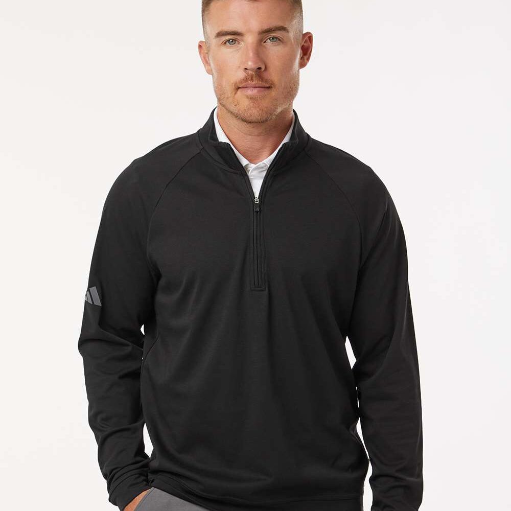 Man in black Adidas golf pullover with grey pants