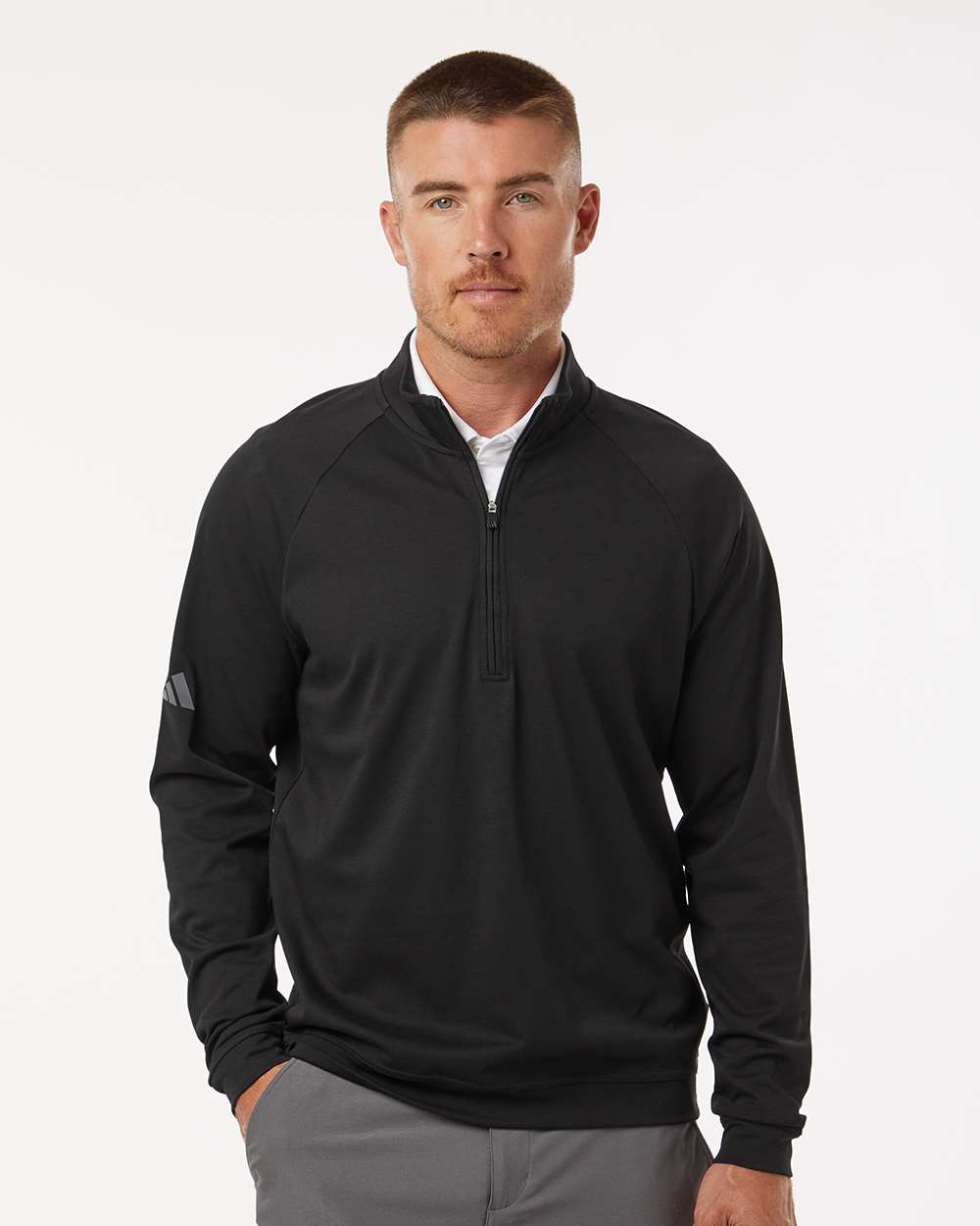 Man in black Adidas golf pullover with grey pants