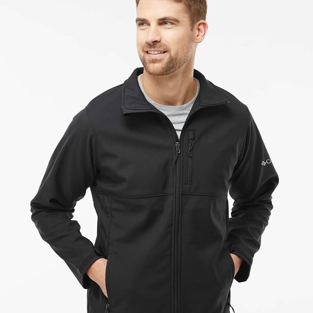 Man in black Columbia softshell jacket with zipped pockets and logo on sleeve