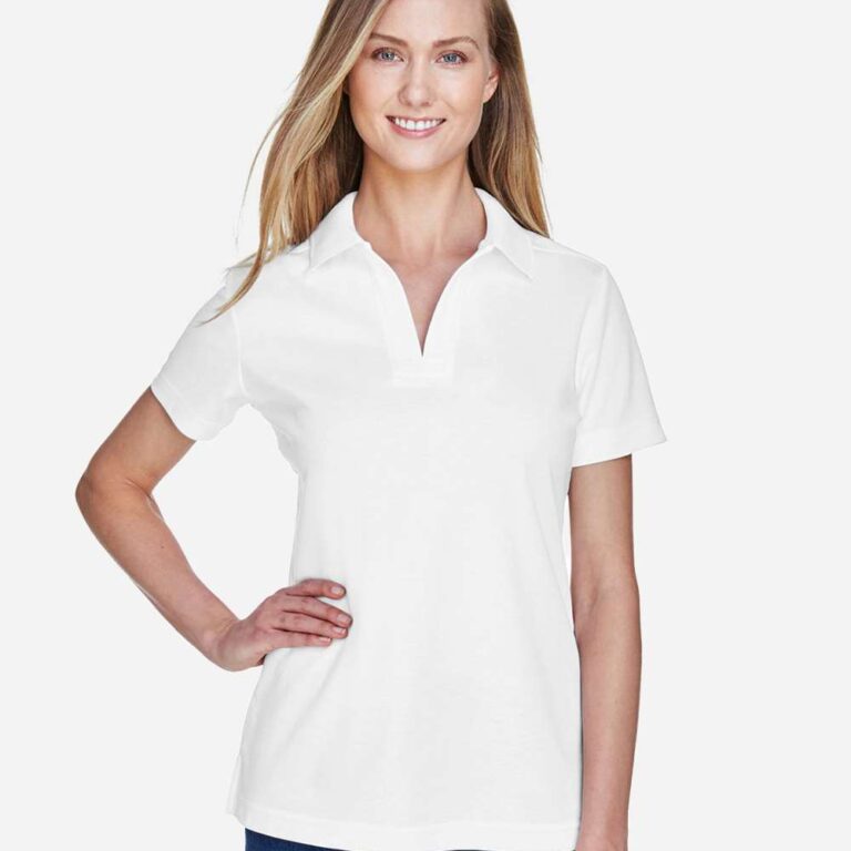Woman wearing a white short-sleeve polo shirt and blue jeans, smiling with hand on hip.