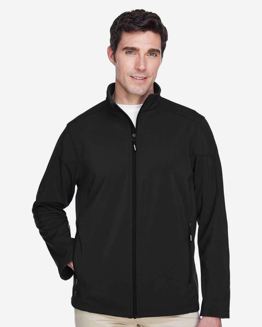 Man in black zippered softshell jacket with white t-shirt and khaki pants