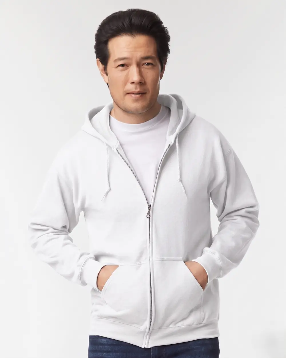 Man wearing white zip-up hoodie with hands in pockets