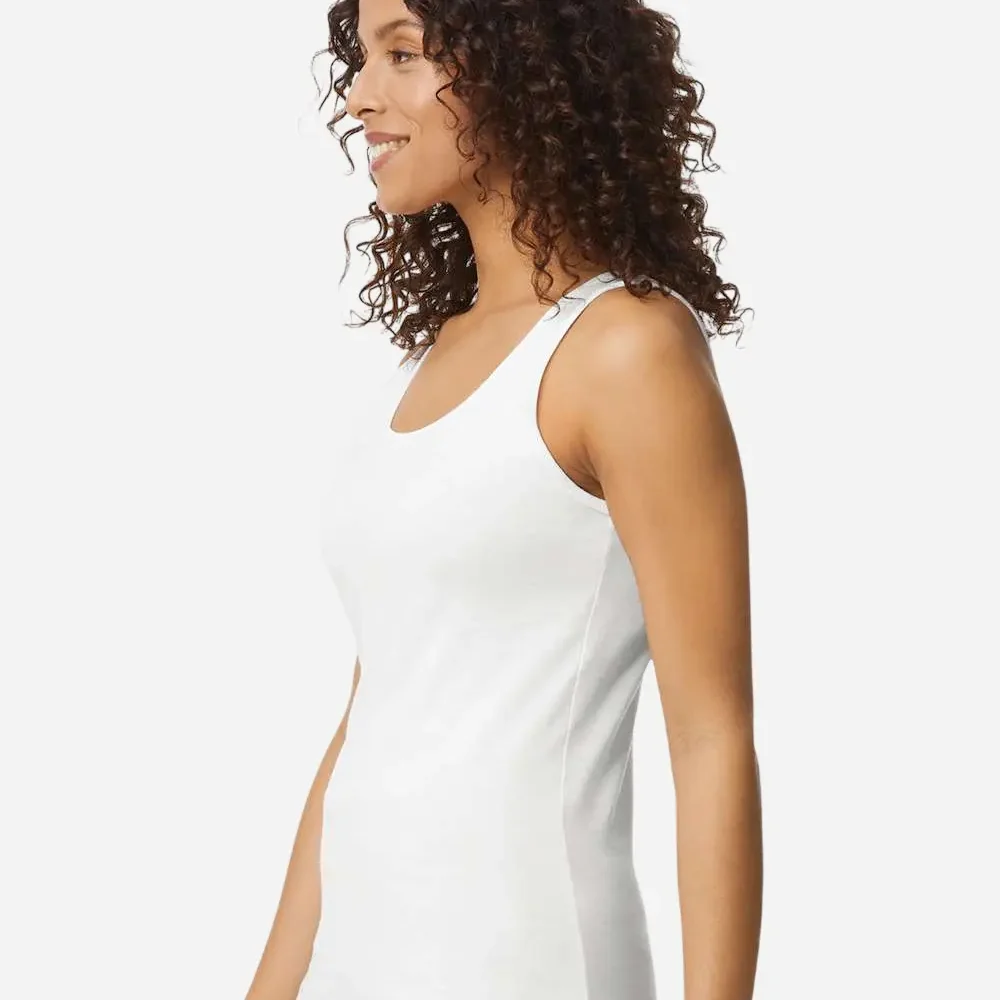 Woman wearing a white tank top and blue jeans, profile view.