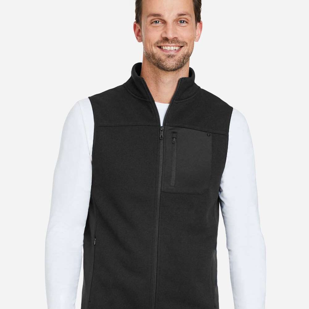 Man wearing a black fleece vest with zipper and chest pocket over white long sleeve shirt