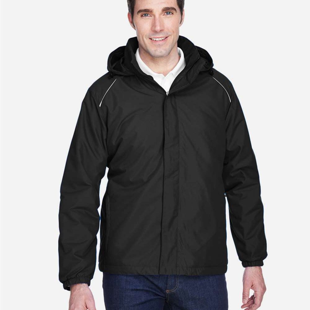 Man in black hooded jacket and jeans, smiling.