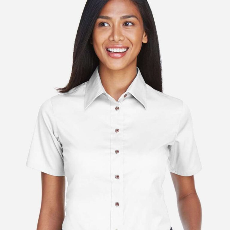Woman in a white short-sleeved button-up shirt and navy trousers with a black belt.