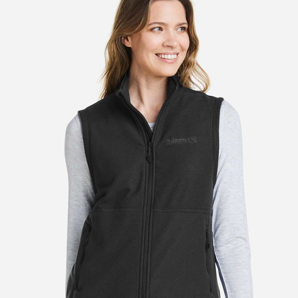 Woman wearing a black Marmot fleece vest over a grey long-sleeved shirt.