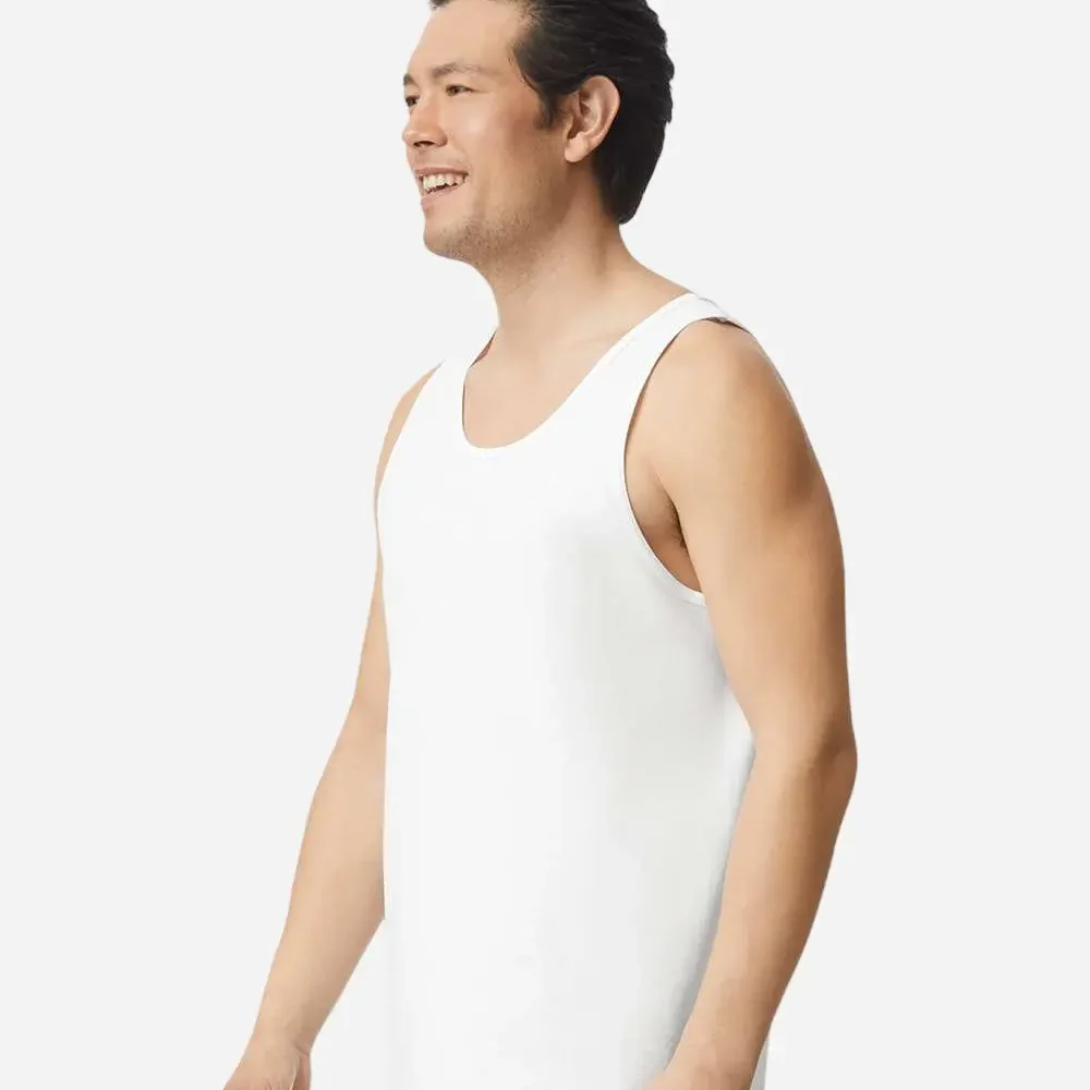 Man wearing a white tank top and blue jeans, smiling and looking to the left.