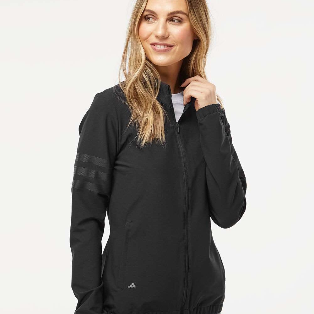 Woman in black Adidas track jacket with grey stripes on sleeve