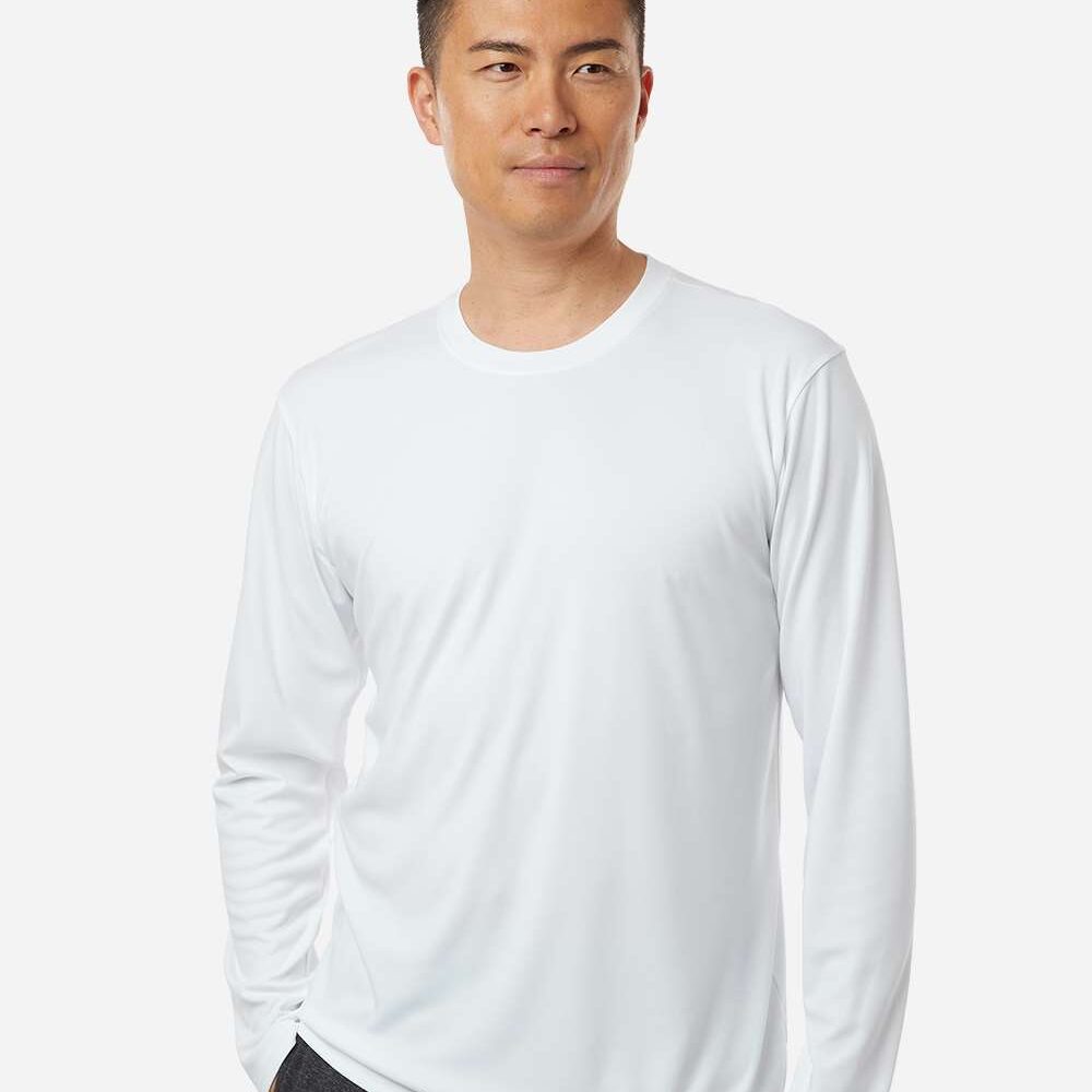 Man wearing a white long-sleeved t-shirt with dark grey trousers.