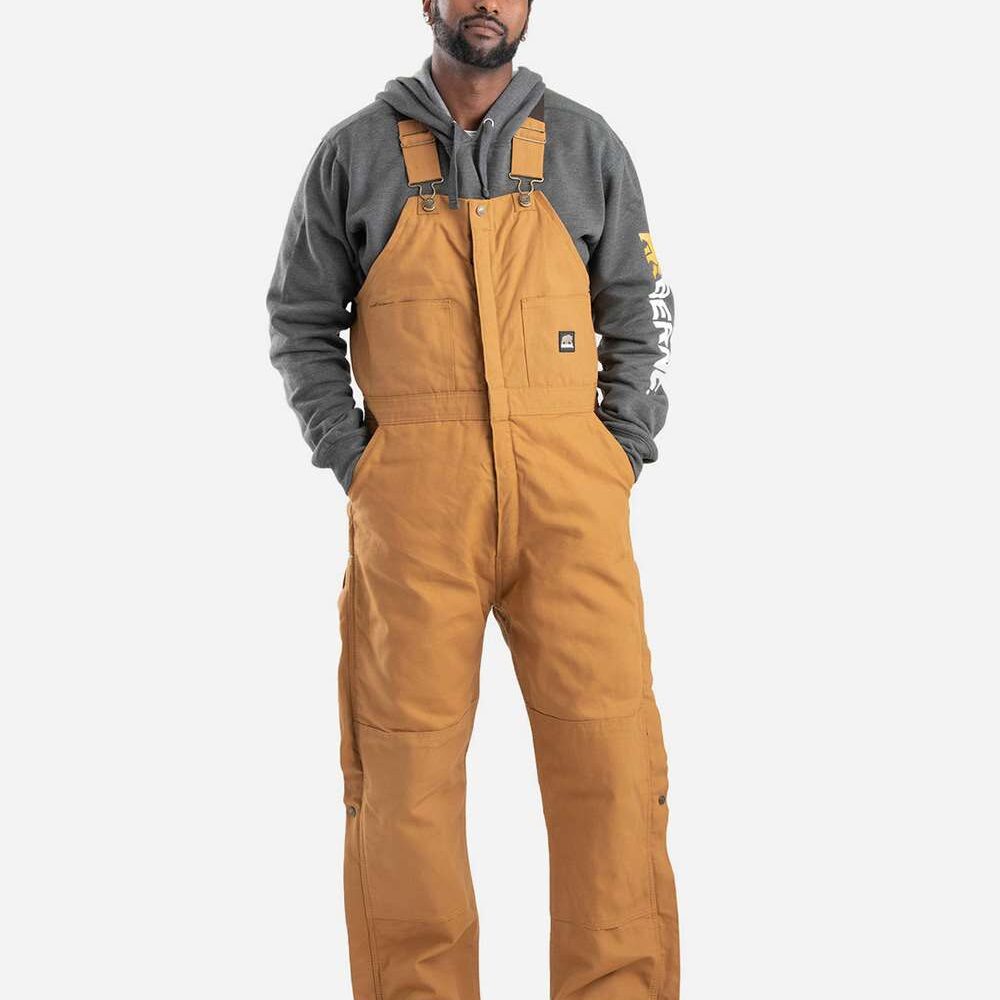 Man wearing brown canvas overalls and grey hoodie