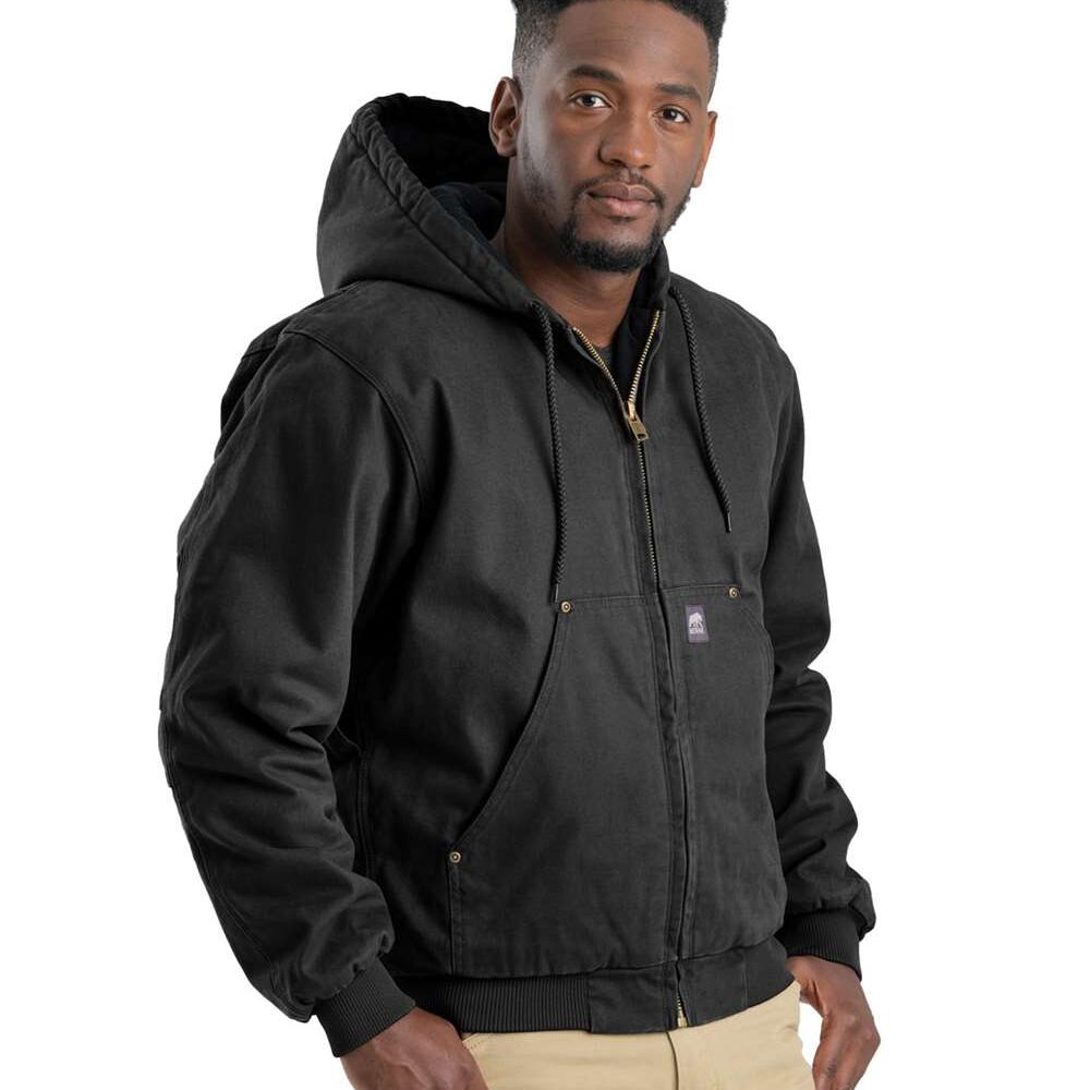 Man wearing a black hooded canvas work jacket and tan pants.