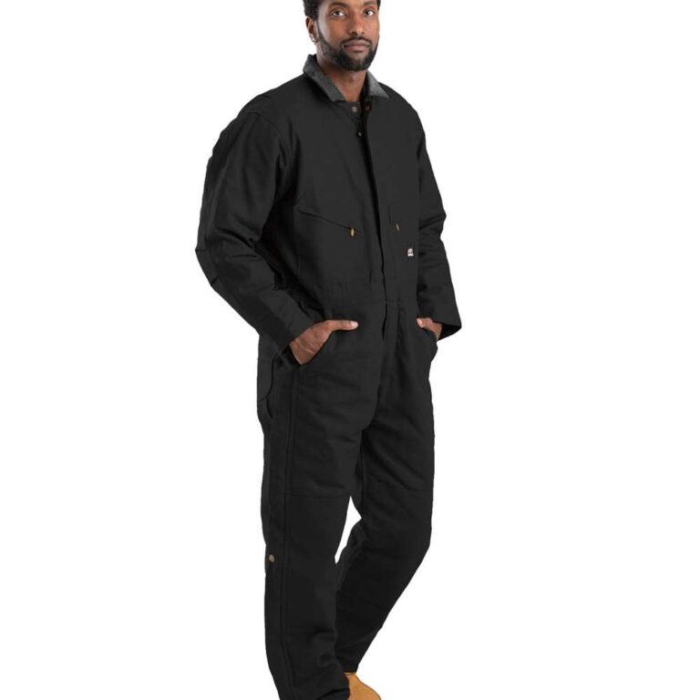 Man in black canvas work jumpsuit and tan work boots, hands in pockets