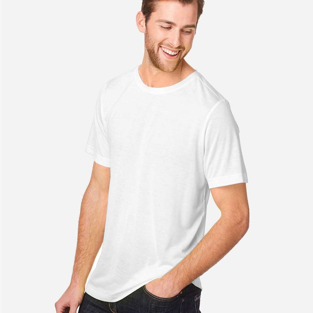 Man in white t-shirt and dark jeans smiles with hand in pocket