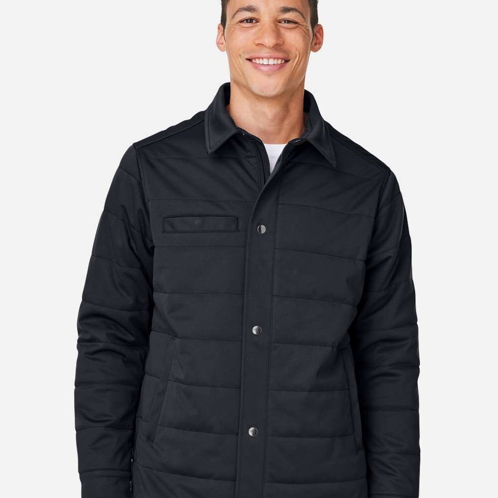Man wearing a quilted dark navy shacket with silver snap buttons and a chest pocket.