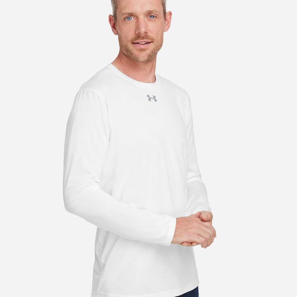 Man in white long-sleeved t-shirt with grey Under Armour logo and dark blue jeans.