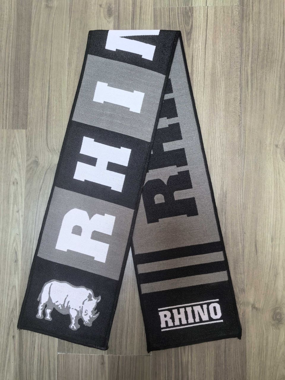 Black and grey rhino scarf with large white letters spelling RHINO and a rhino graphic.