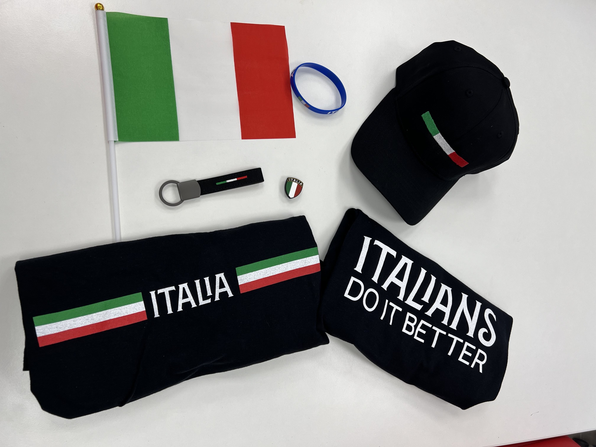 Italian flag, cap, keychain, and apparel with "ITALIA" and "ITALIANS DO IT BETTER" text.