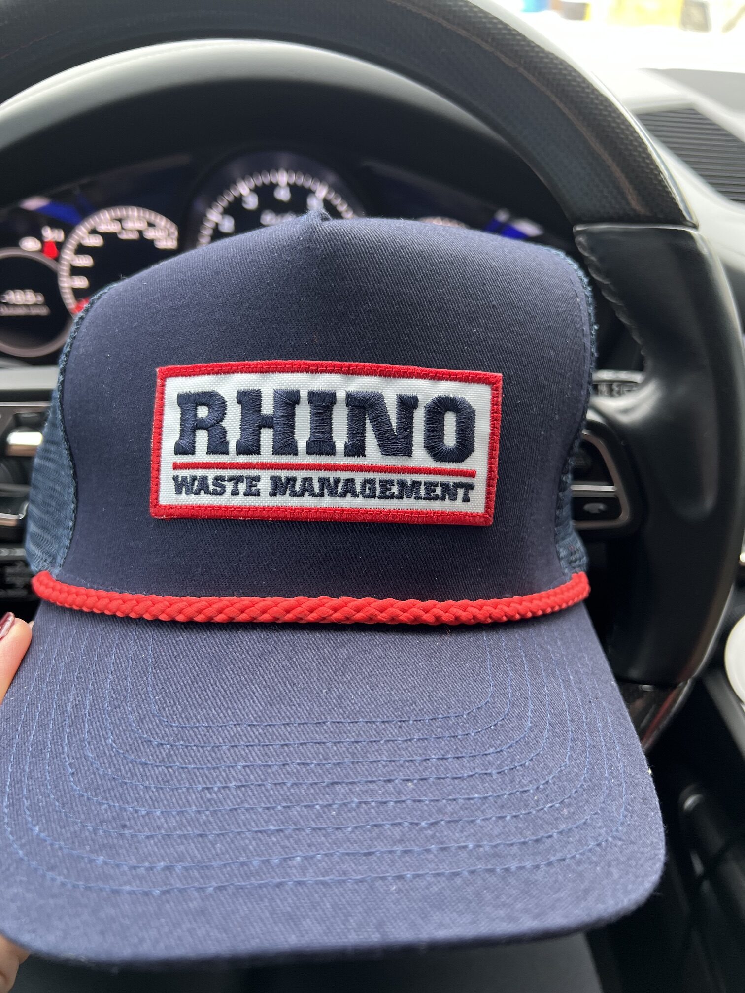 Navy blue Rhino Waste Management trucker hat with red rope detail