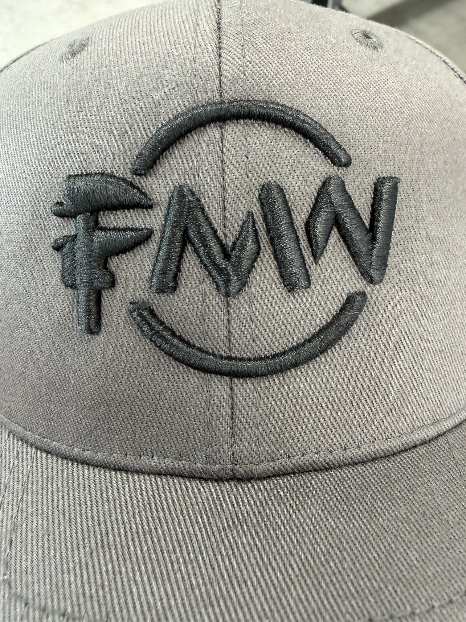 Grey baseball cap with embroidered black FMW logo
