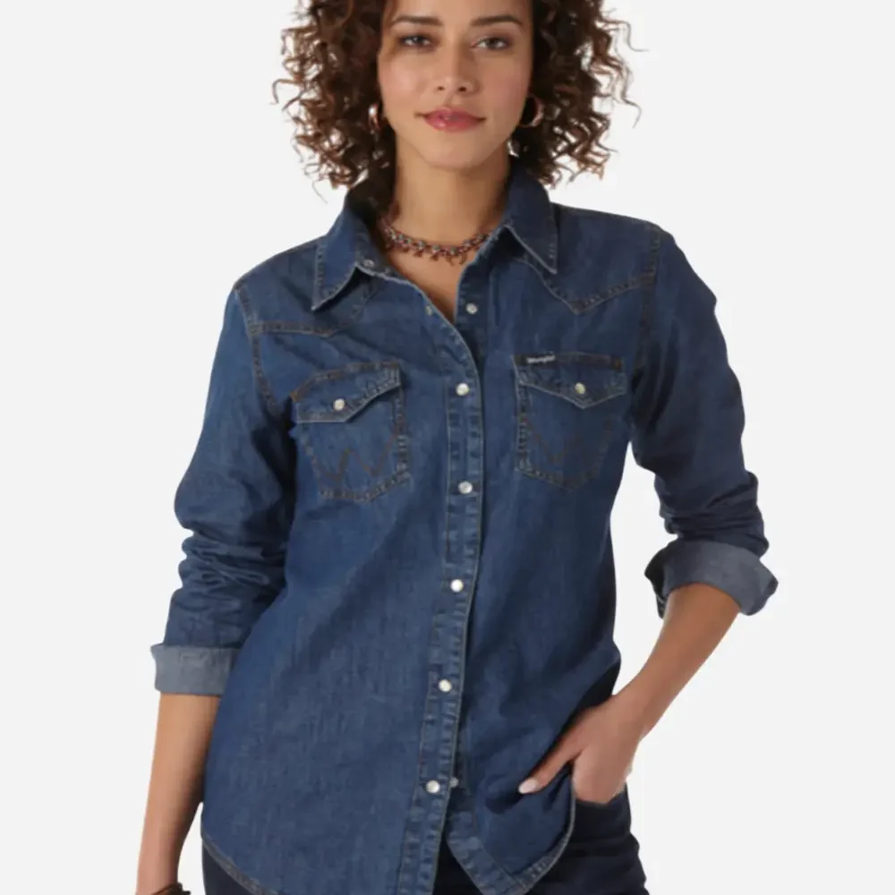 Woman in blue denim western shirt with rolled up sleeves and dark jeans